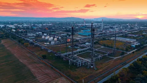 Bright orange sky over the vast scenery of industrial plant. Modern oil refinery Stock Footage 343795500