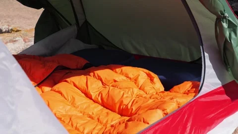 Bright orange sleeping bag in open tent, outdoor camping, Portugal Stock Footage 320639009