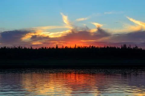 Bright orange sunset behind the clouds of sun on the banks of the Northern ri Foto stock