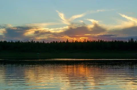 Bright orange sunset behind the clouds of sun on the banks of the Northern ri Stock Photos