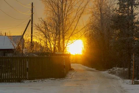 Bright orange sunset on a rustic quiet street in early winter 스톡 사진