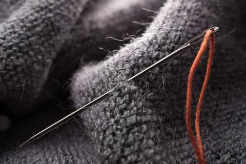 Bright orange thread and needle on fabric Stock Photos
