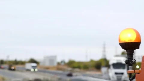 A bright orange warning light mounted on construction equipment, against th.. Video stock 329869024