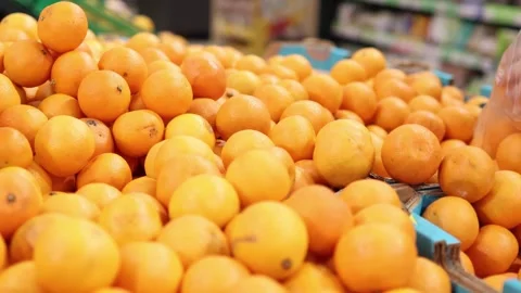 Bright oranges await selection at a bustling market Stock-Footage 296147038