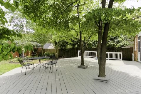 Bright Outdoor Deck With Leafy Trees And Various Seating Arrangements Stock Photos