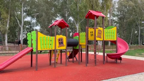 Bright outdoor play area features multicolored structures and safe rubber ground Stock Footage 334318062