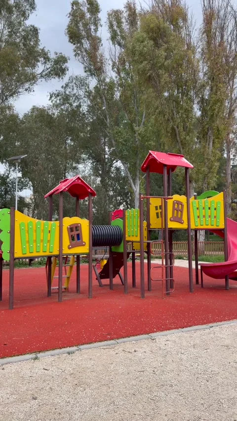 Bright outdoor play area with multicolored structures and safe rubber ground in Video stock 334577671