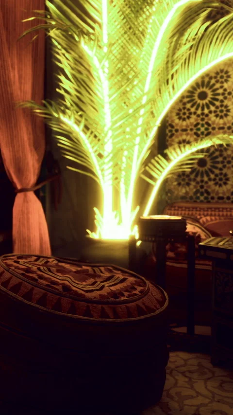 Bright palm tree in a room setting with patterned wall and cushions 库存影片 331754015