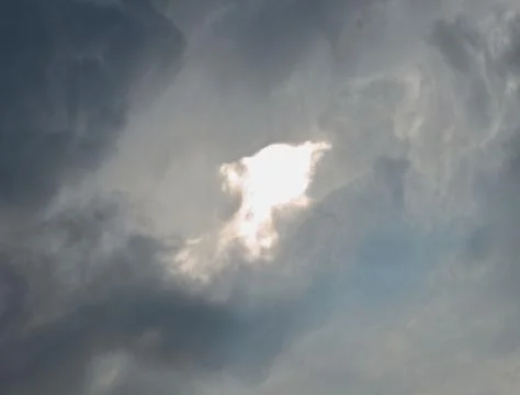 Bright part of sky surrounded by clouds Stock Photos