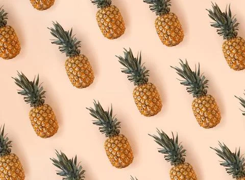 Bright pattern of many pineapples on a trendy soft beige pink background Stock Photos