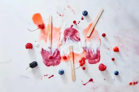 Bright pattern of splashes of ice cream of different fresh berries and sticks on Foto stock