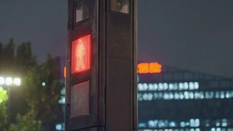 Bright pedestrian stop light beside illuminated city office. Night scene showing Stock Footage 335179004