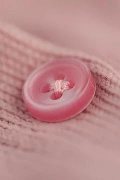 Bright pink button on soft fabric in close up view Stock Photos