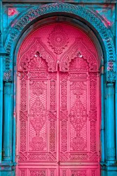 A bright pink door with oriental patterns and a blue frame. Art oriental ar.. Stock Photos