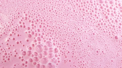 Bright pink foamy milkshake or strawberry smoothie with bubbles rotation 스톡 동영상 233997461