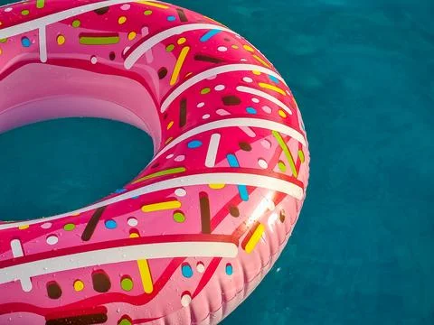 Bright pink inflatable ring floating in swimming pool. Vacation concept with Stock-Fotos
