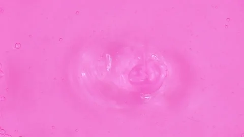 Bright pink transparent moisturizing face cosmetic gel texture flowing close up Stock Footage 236932031