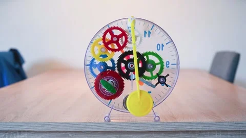 Bright plastic clockwork toy showing gears and pendulum Stock Footage 320491772