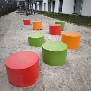 Bright play modules on a sandy playground in a residential area Stock Photos