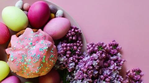 Bright purple easter eggs, cake and lilac flowers on a purple background. Eas Fotos Stock