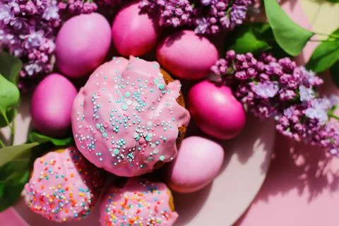 Bright purple easter eggs, cake and lilac flowers on a purple background. Eas 스톡 사진