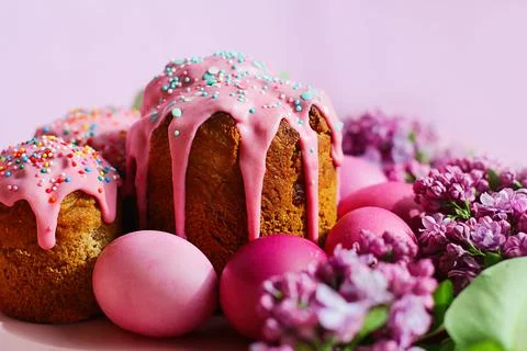 Bright purple easter eggs, cake and lilac flowers on a purple background. Eas Photos