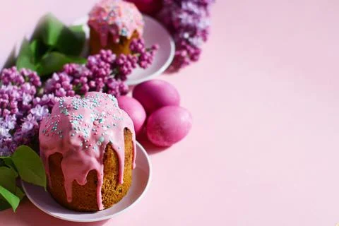 Bright purple easter eggs, cake and lilac flowers on a purple background. Eas Fotos de archivo