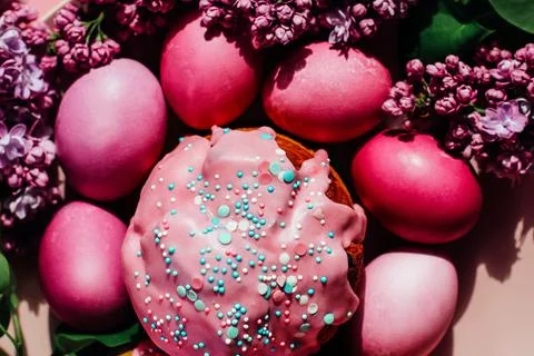 Bright purple easter eggs, cake and lilac flowers on a purple background. Eas 写真素材