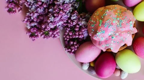 Bright purple easter eggs, cake and lilac flowers on a purple background. Easter 库存照片