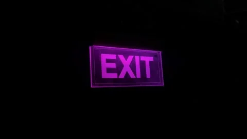 Bright purple emergency exit sign glowing against a dark background, safety.. Stock Footage 346597462