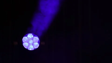 Bright purple LED stage spotlight emitting beam through smoke Stock Footage 346343972