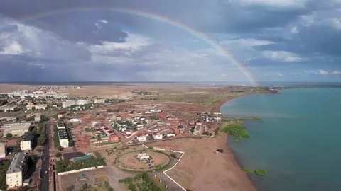 Bright rainbow and rain over the city near lake Stock Footage 202131675