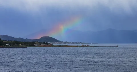 Bright rainbow arches over a lush mountain island Stock Footage 312315465