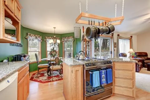 Bright rambler kitchen boasts vaulted ceiling over bar style kitchen island w Stock Photos