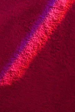 Bright ray of light fallen on wine red carpet close view Stock Photos
