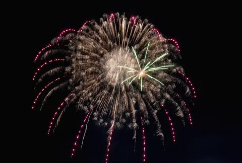 Bright rays of light from explosion of festive fireworks against black Foto stock