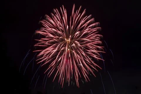 Bright rays of light from explosion of festive fireworks against black Foto stock