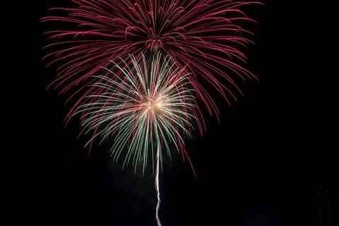 Bright rays of light from explosion of festive fireworks against black Foto stock