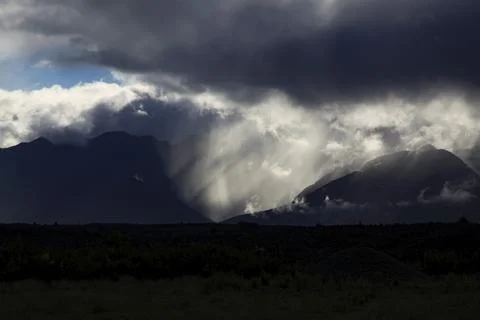 Bright rays of light intersect against a dark sky Stock Photos