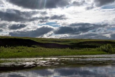 Bright rays of the sun breaking through the clouds in the sky. Stock Photos