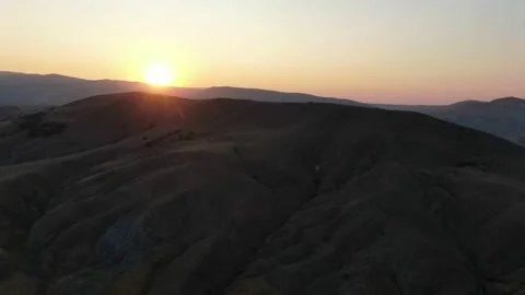 Bright rays of the sun at sunset over the slopes of the hills aerial drone shoot Video stock 132176371
