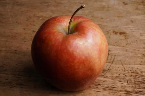 Bright red apple displayed on rustic wooden table Stock Photos