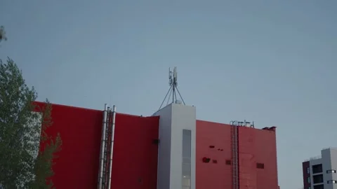Bright red building facade under a clear blue evening sky Stock Footage 334627066