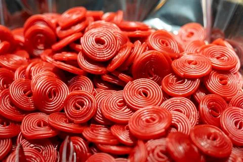 Bright red candy spirals in close-up view, showcasing texture and color at a Foto stock