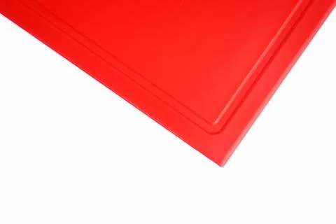 Bright red clean plastic cutting board with a kitchen knife on a white Stock Photos