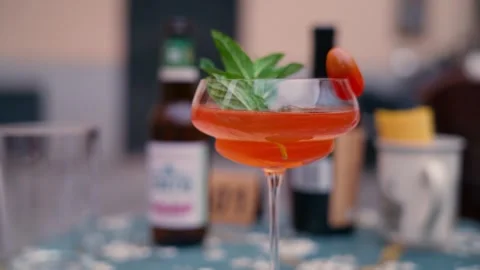 Bright Red Cocktail Garnished With Mint And Cherry Tomato On Ice Stock Footage 341465770