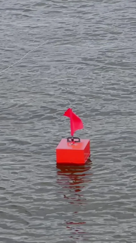 Bright Red Course Marker Buoy Floating on Rippling Water 動画素材 345095292