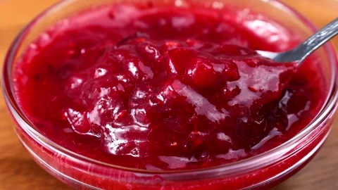 Bright red cranberry sauce taking with a spoon close up Stock Footage 277685472