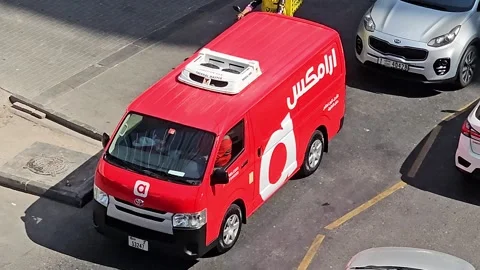 Bright red delivery van with white aramex logo on side, moving on asphalt Stock Footage 311766291