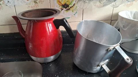 Bright red enameled coffee filter pot beside a silver metal container Stock Photos